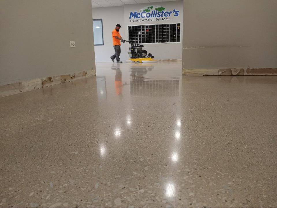 Technician operating a diamond grinder on a warehouse floor
